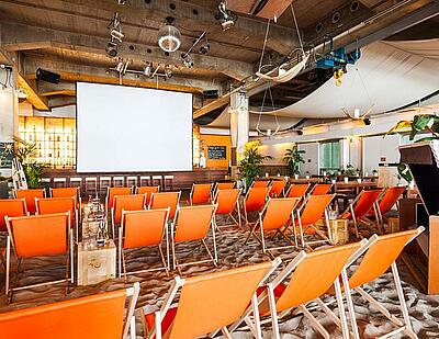 Innenbereich des beach38grad in München Innenbereich mit Sonnenstühlen und Leinwand im beach38grad in München
