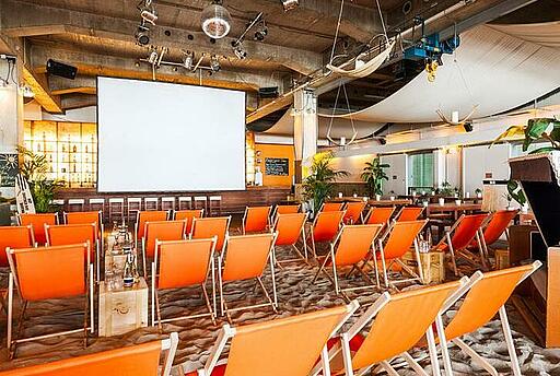 Innenbereich des beach38grad in München Innenbereich mit Sonnenstühlen und Leinwand im beach38grad in München