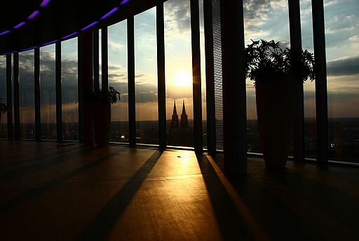 Innenansicht des KölnSKY Sonnenuntergang durch bodentiefe Fenster im  KölnSKY