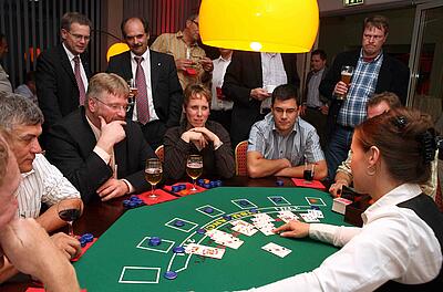 Blackjack-Tisch als Idee für ein Come Together Croupier fragt nach nächster Karte beim Blackjack.