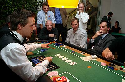 Poker-Tisch bei einem Come Together Messeevent der Makino Europe GmbH Dealer erklärt die Spielregeln beim Pokern.