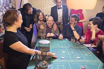Spieler freut sich über Gewinn beim Chuck a Luck-Spiel Spieler und Gäste freuen sich über Gewinn beim Chuck a Luck-Spiel