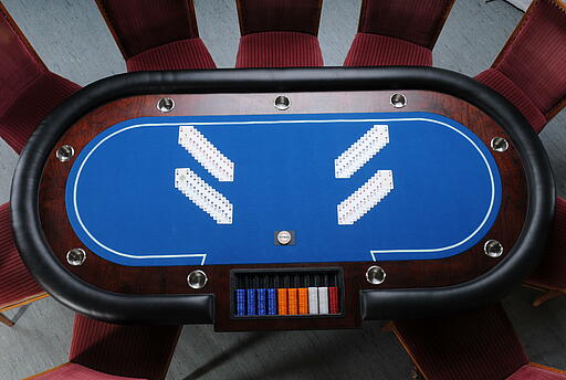 Vogelperspektive eines großen Poker-Tischs mit Spielkarten und Jetons Vogelperspektive eines großen Poker-Tischs mit Spielkarten und Jetons